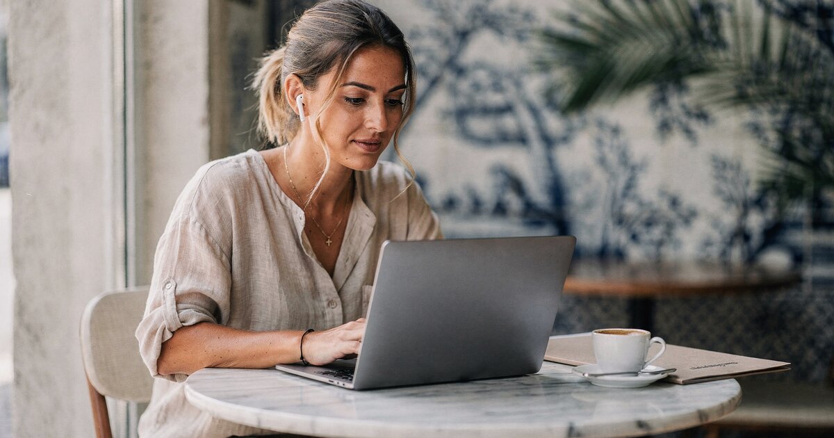 Freelancer am Laptop mit Vertragsdokument — Haftungsklauseln im Vorher/Nachher-Vergleich