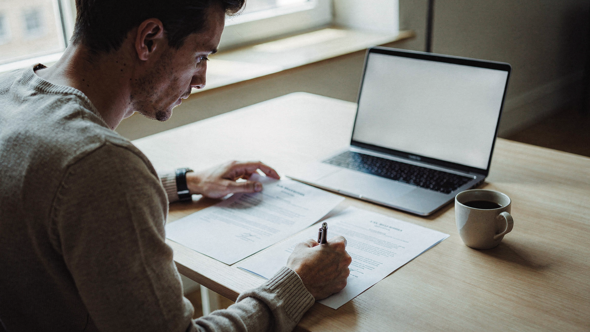 Freelancer vergleicht zwei Verträge am Schreibtisch — Werkvertrag vs. Dienstvertrag